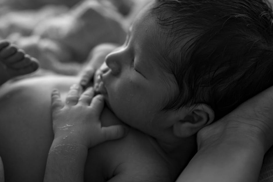 Close-up of a peaceful newborn baby sleeping, capturing tender moments in black and white.