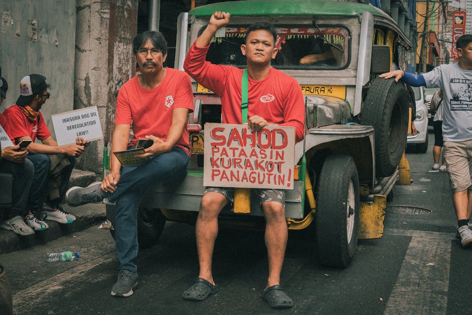 Men protesting in Manila, demanding higher wages and accountability, sitting on a jeepney in the street.