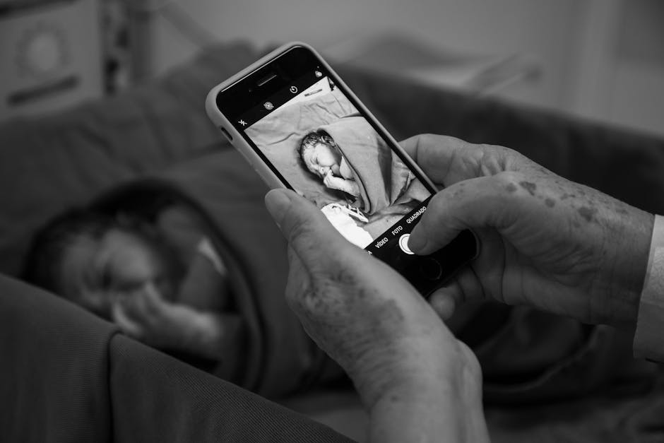 A touching black and white photo capturing a grandparent photographing their newborn grandchild.