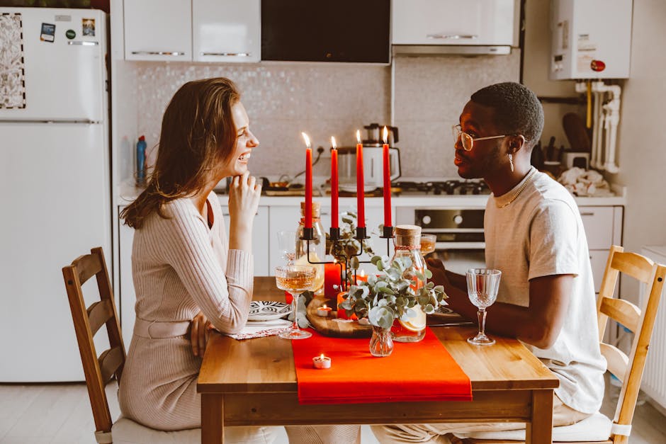 A couple enjoying a romantic candlelit dinner at home with wine and decor.