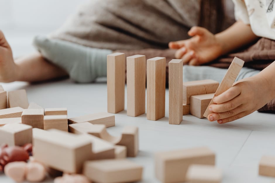 Young child engaging with wooden blocks, encouraging creativity and fine motor skills.