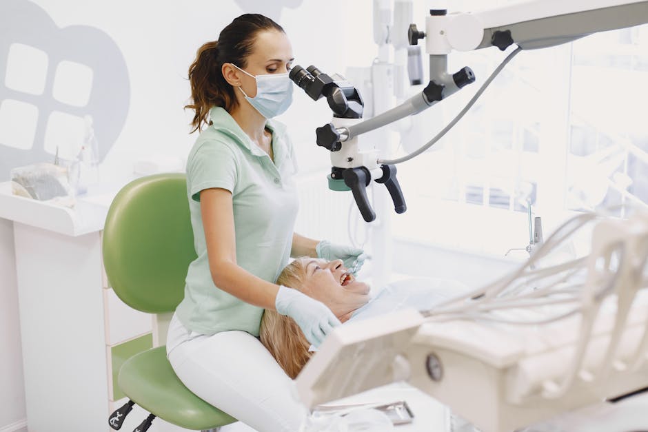 Dentist performing an examination using a microscope in a bright dental clinic.