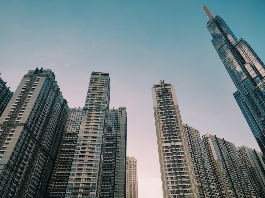 Modern skyscrapers under a blue sky in an urban cityscape at dusk.