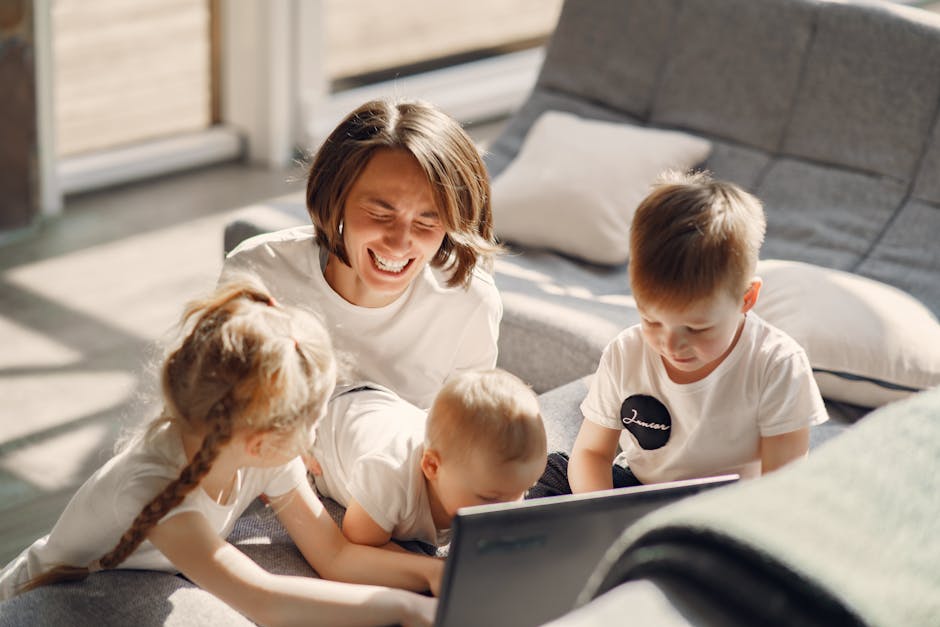 From above of cheerful woman laughing while playing with children while sitting on sofa in well lit living room