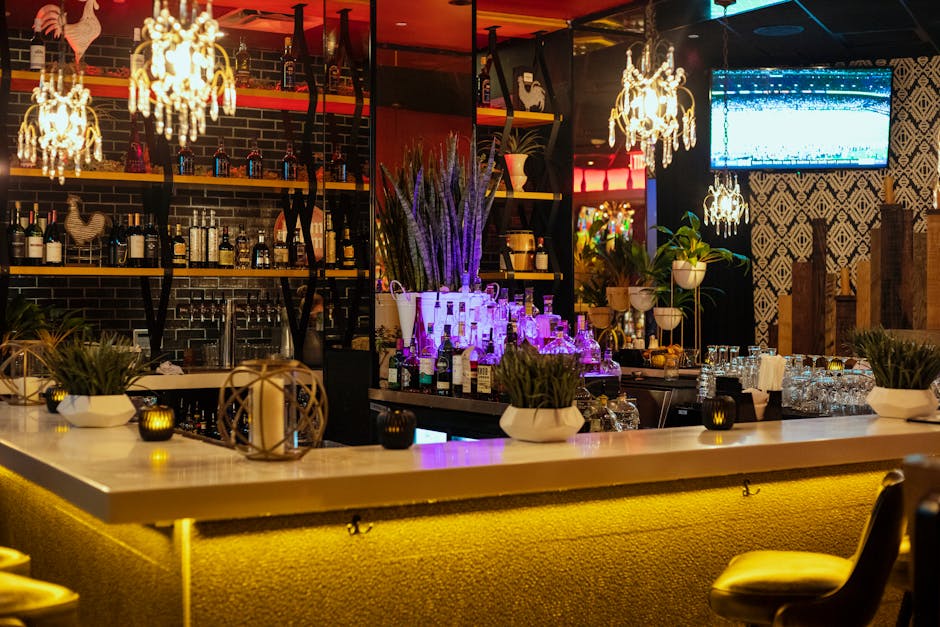 Stylish bar interior with decorative lighting, plants, and a well-stocked counter.