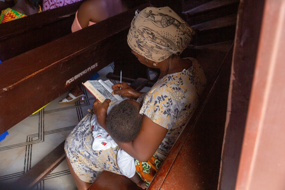 A woman and child are sitting in a church pew, reading and resting.
