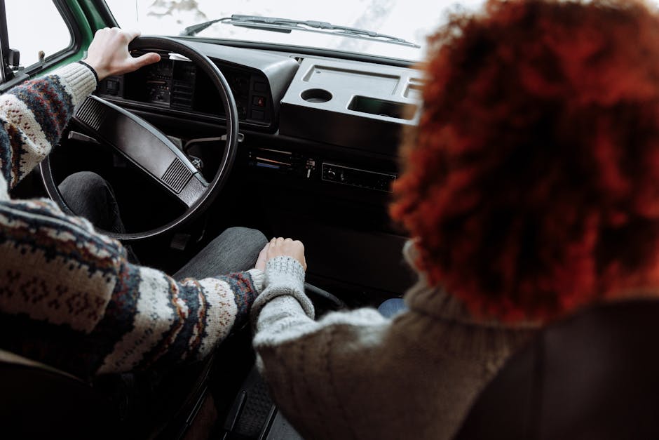 A couple enjoying a cozy road trip in a vintage campervan, wearing warm sweaters and holding hands.