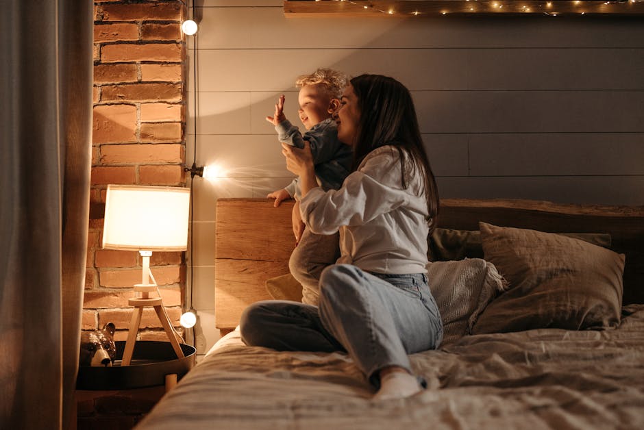 A mother lovingly plays with her child in a warmly lit bedroom, creating a cozy atmosphere.