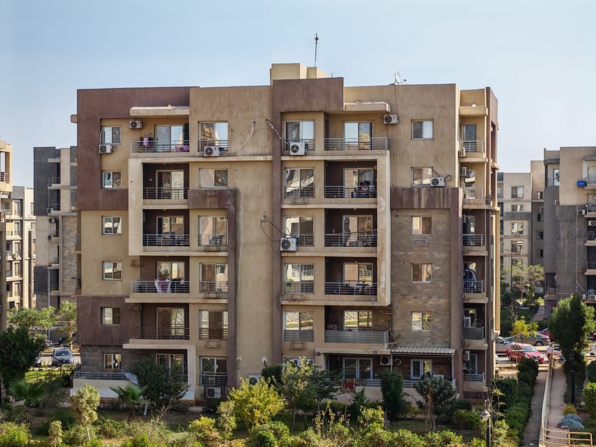 A contemporary apartment building with balconies in a cityscape.