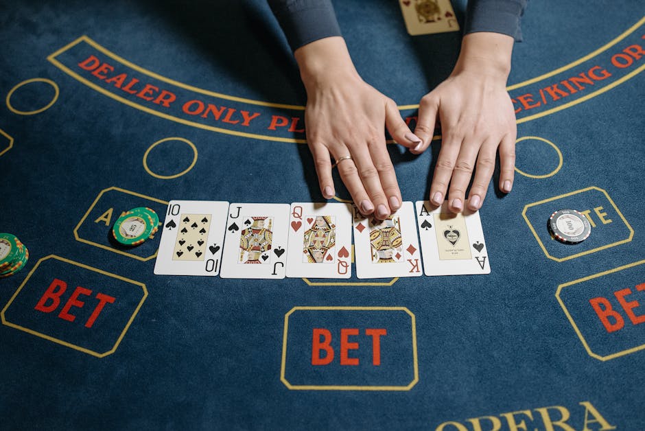 Top view of a casino game with a dealer revealing a winning poker hand on a felt table.