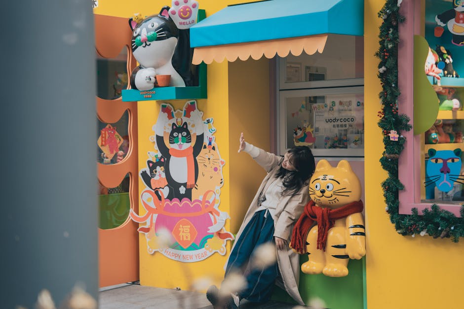 Woman posing next to vibrant cat-themed decorations in a playful outdoor setting.