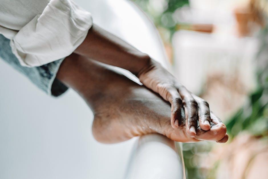 Close-up of a person's feet resting on a bathtub edge, conveying relaxation and self-care.
