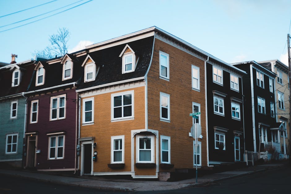 Vibrant row houses line an urban street, showcasing unique architectural design and colorful facades.
