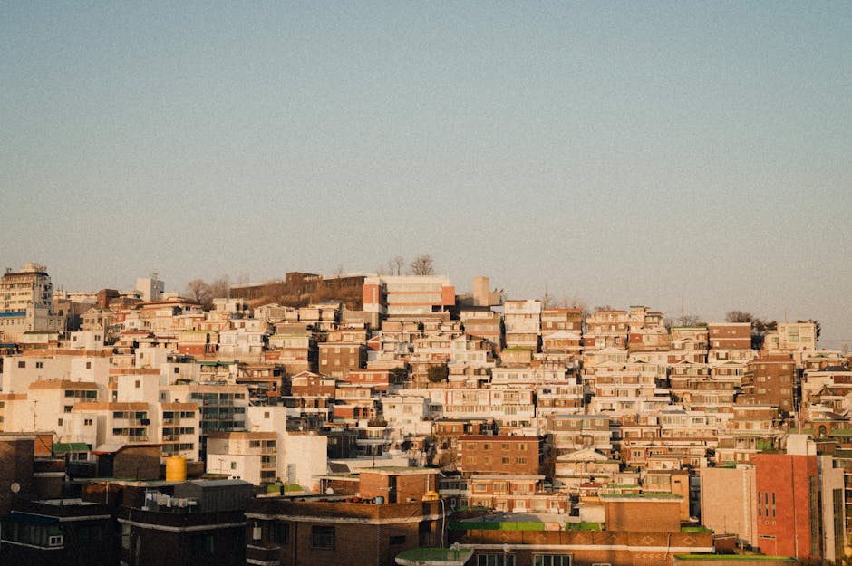 Aerial view of dense urban residential buildings under a clear sky during dusk, showcasing urban architecture.