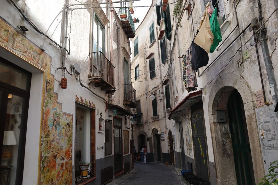Explore the rustic charm of a narrow street in Vietri sul Mare, Italy, adorned with local art.