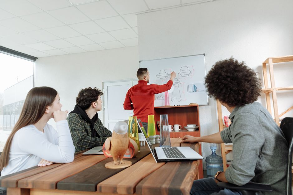 Group of young adults collaborating on design ideas in a modern office setting.