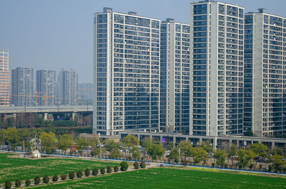 Aerial view of modern high-rise apartments and green spaces in an urban setting.