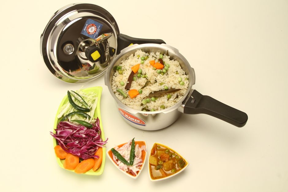 Delicious Indian vegetable pulao cooked in a pressure cooker with fresh side dishes.