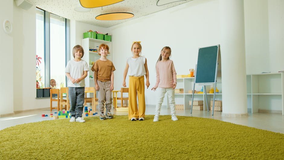 Four cheerful children standing in a well-lit classroom with playful decor.