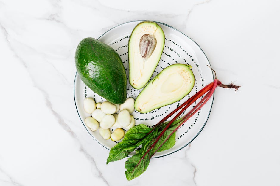 Top view of fresh avocado, beetroot, and broad beans on a plate, perfect for healthy food concepts.