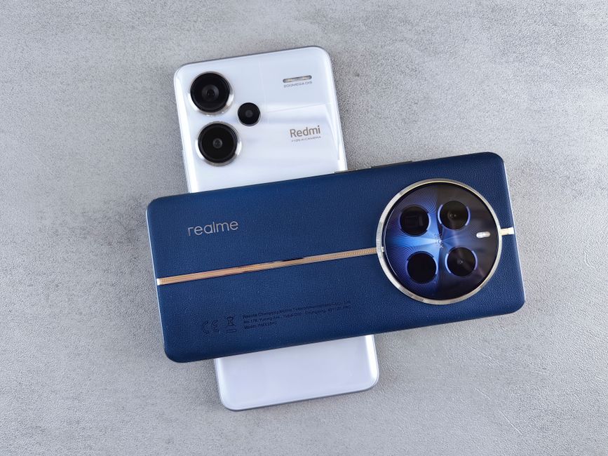 Close-up view of Realme and Redmi smartphones placed on a grey textured surface, showcasing modern technology design.