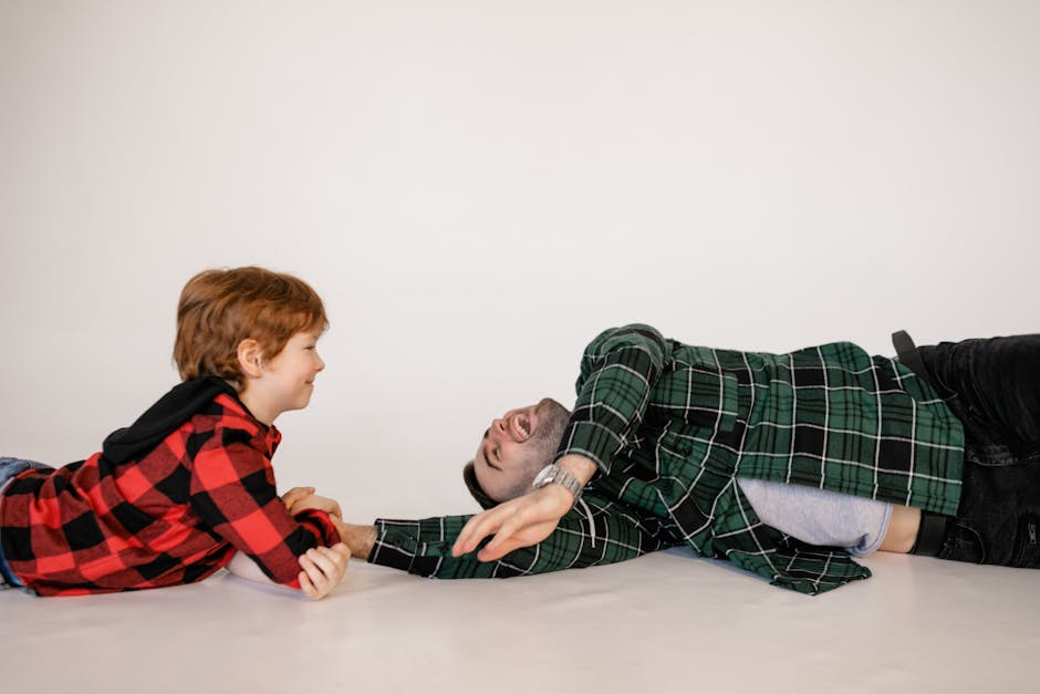A joyful moment of father and son bonding together indoors, capturing family happiness.