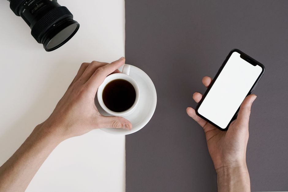 Minimalist workspace featuring a smartphone and black coffee, perfect for productivity and relaxation.