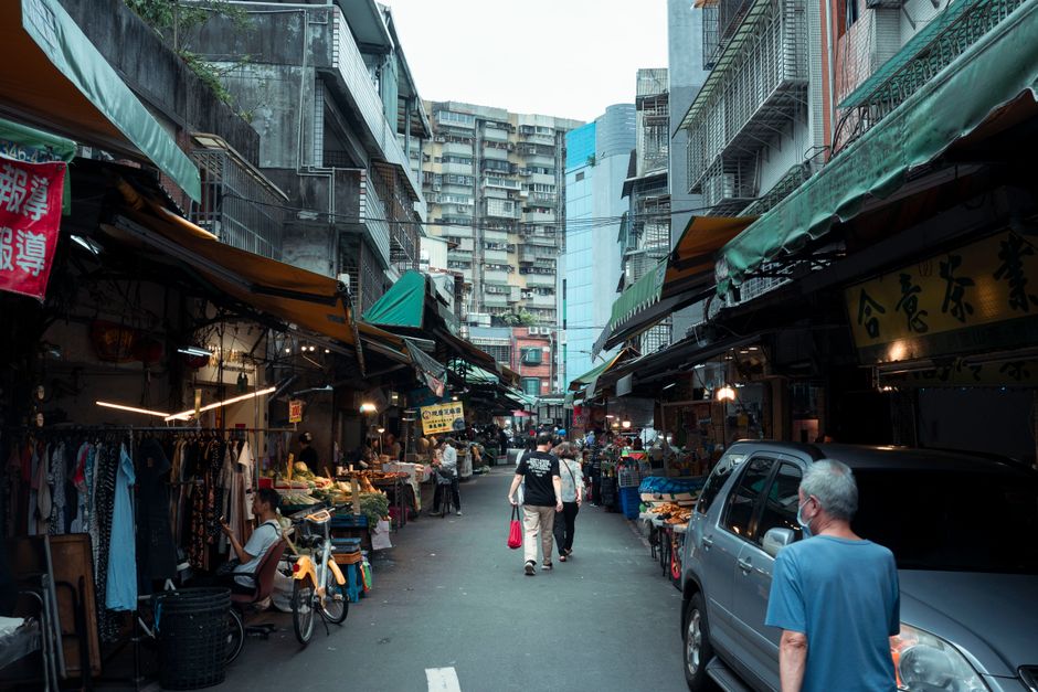 Bustling Taipei street market with shops, people, and urban vibe, capturing local daily life.