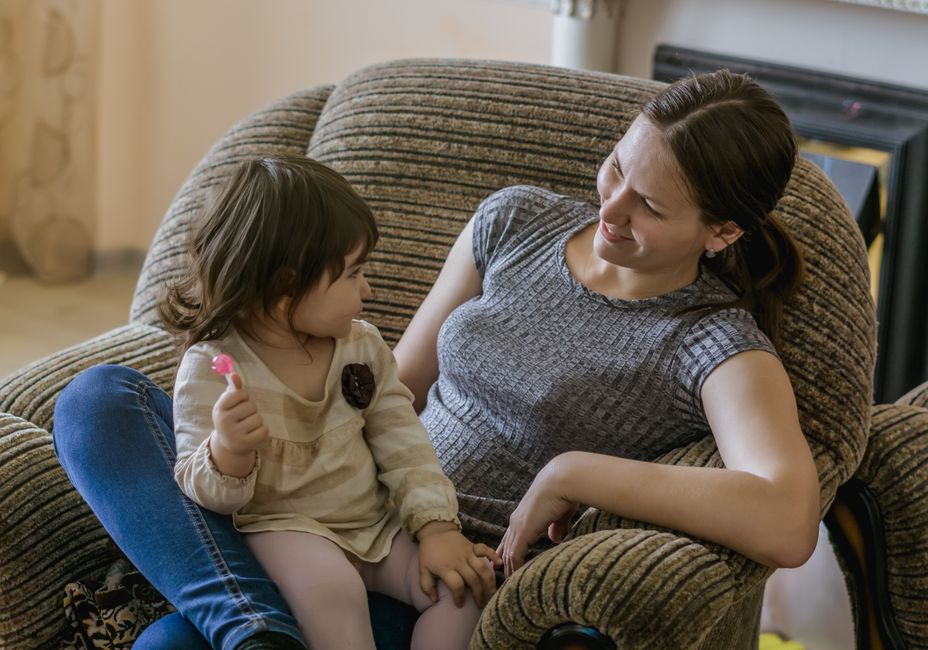 A heartwarming scene of a mother and daughter enjoying quality time on a comfortable couch.