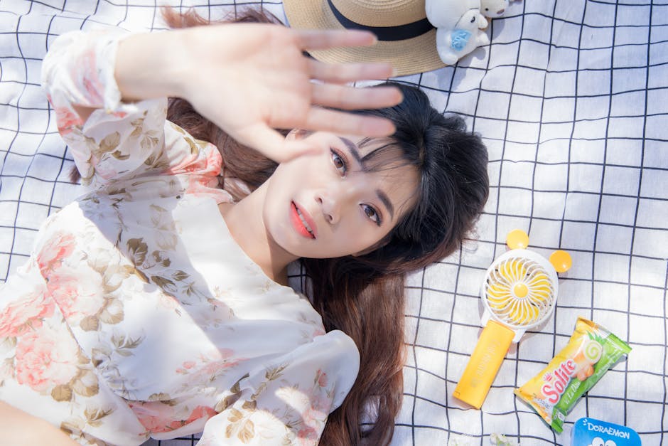 Young woman in floral dress relaxing outdoor on a sunny day, capturing a moment of leisure.