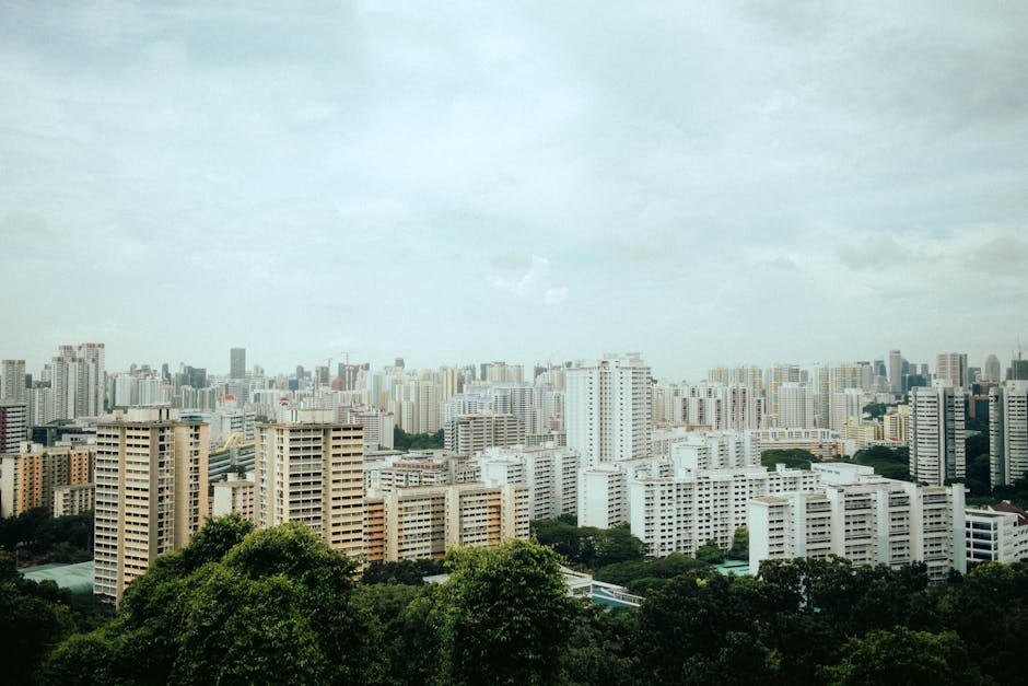 Aerial view of Singapore's urban skyline with modern architecture amidst greenery.