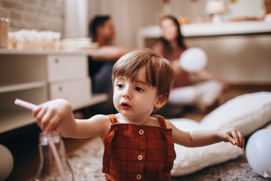 Adorable toddler plays with bubbles during a cozy family gathering indoors.