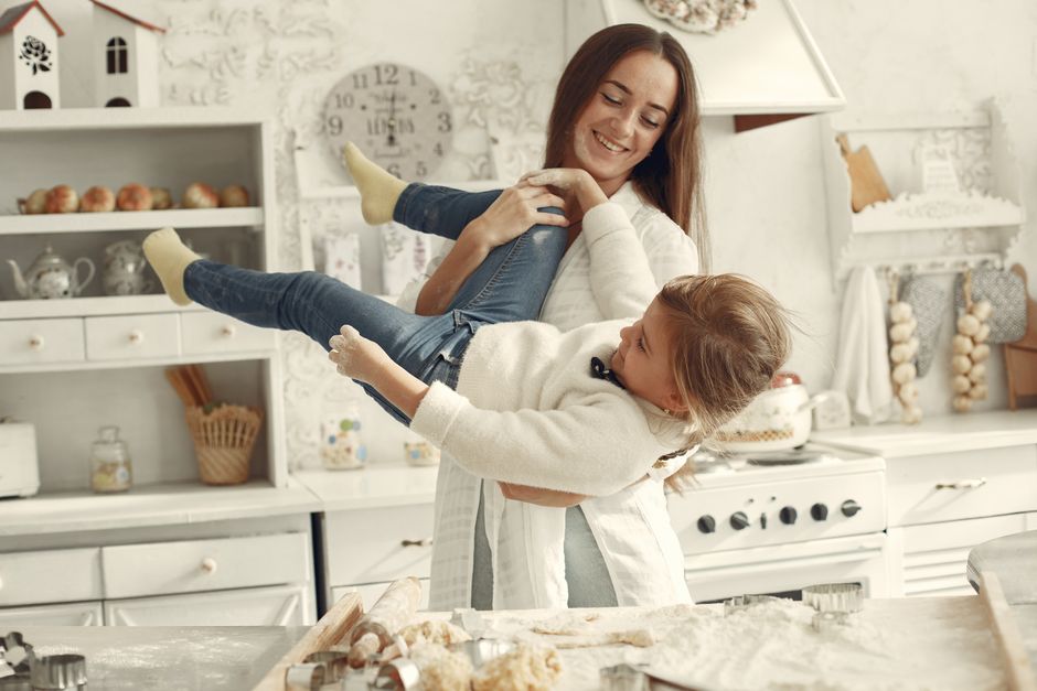 A joyful moment in the kitchen with a mother and daughter playing together during baking.