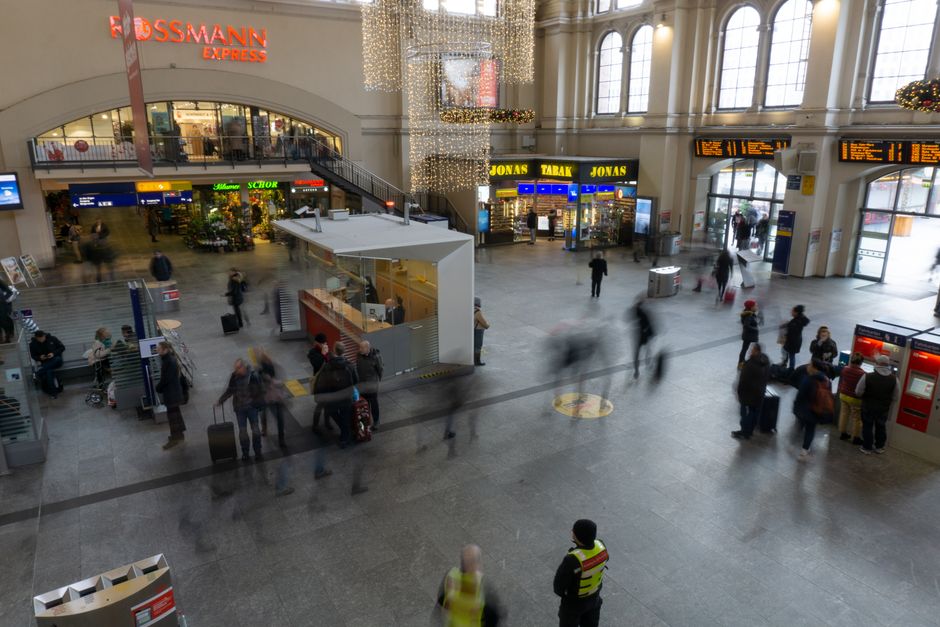 A bustling train station with blurred commuters, showcasing movement and travel.