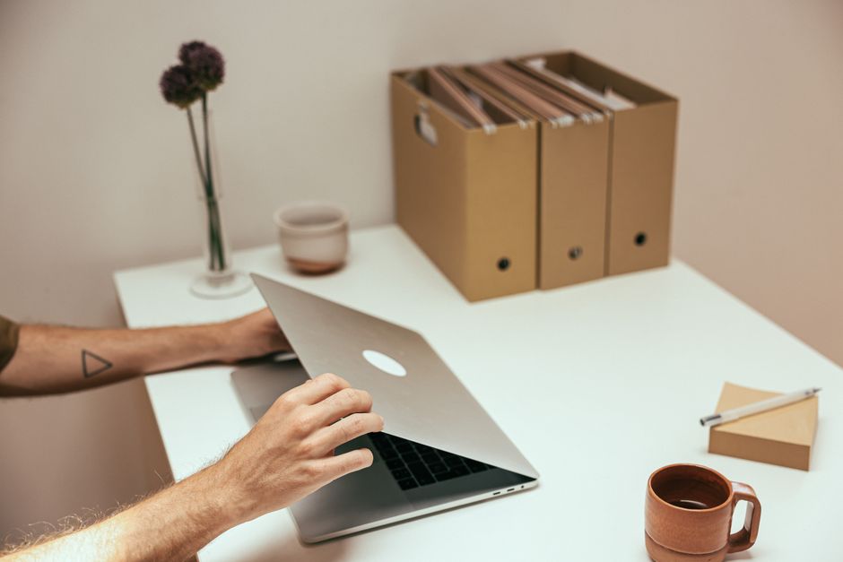 A clean and organized workspace featuring a laptop, coffee mug, and stationery, perfect for productivity.