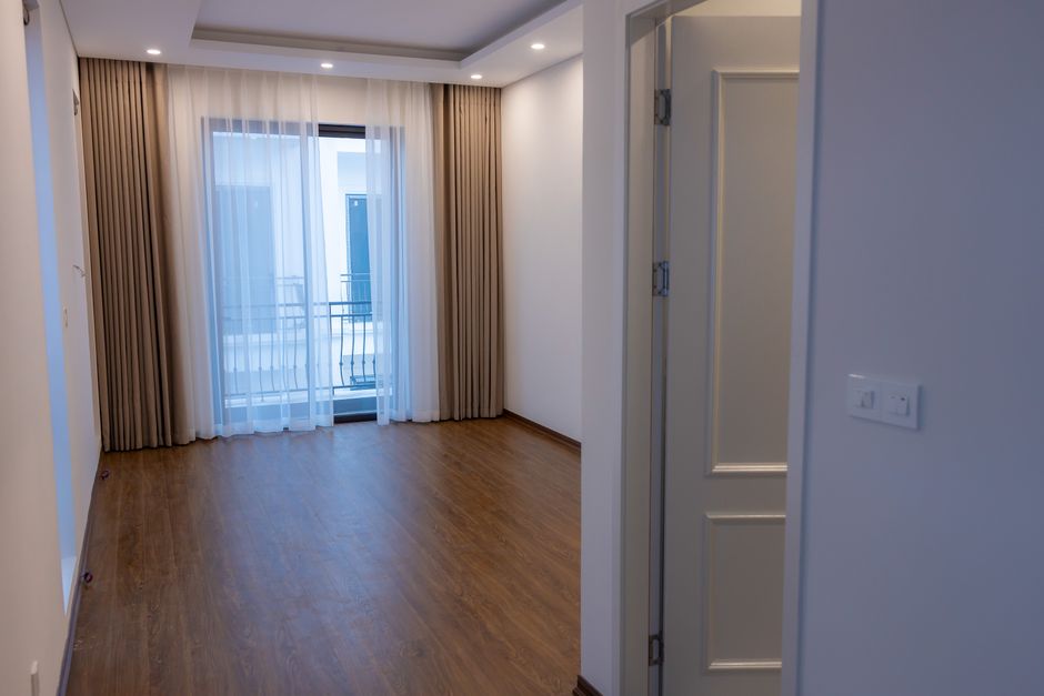 Bright empty room with wooden floor and balcony, ideal for interior design projects.