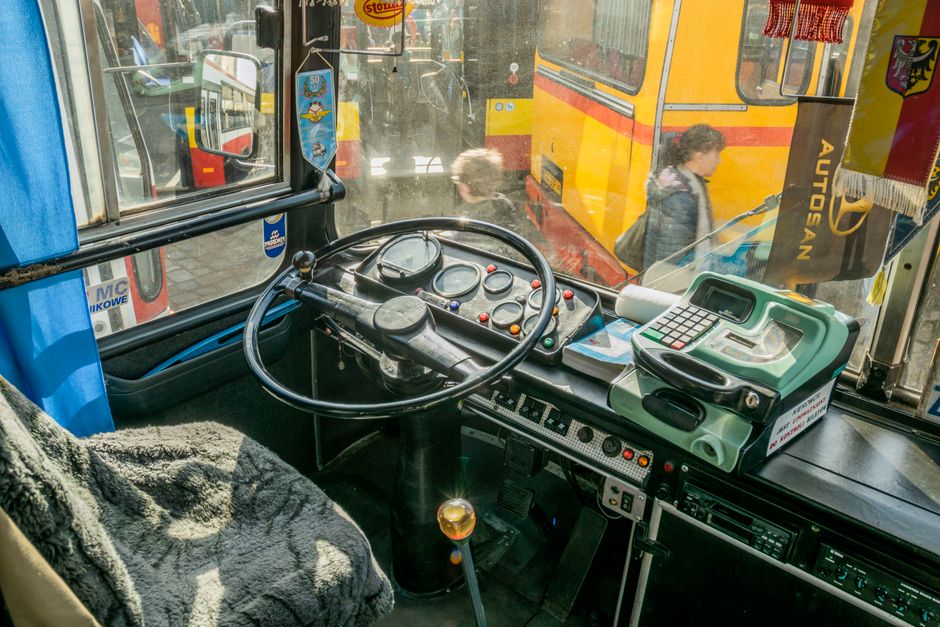 Interior of a vintage bus at Wrocław station with focus on driver's seat and control panel.