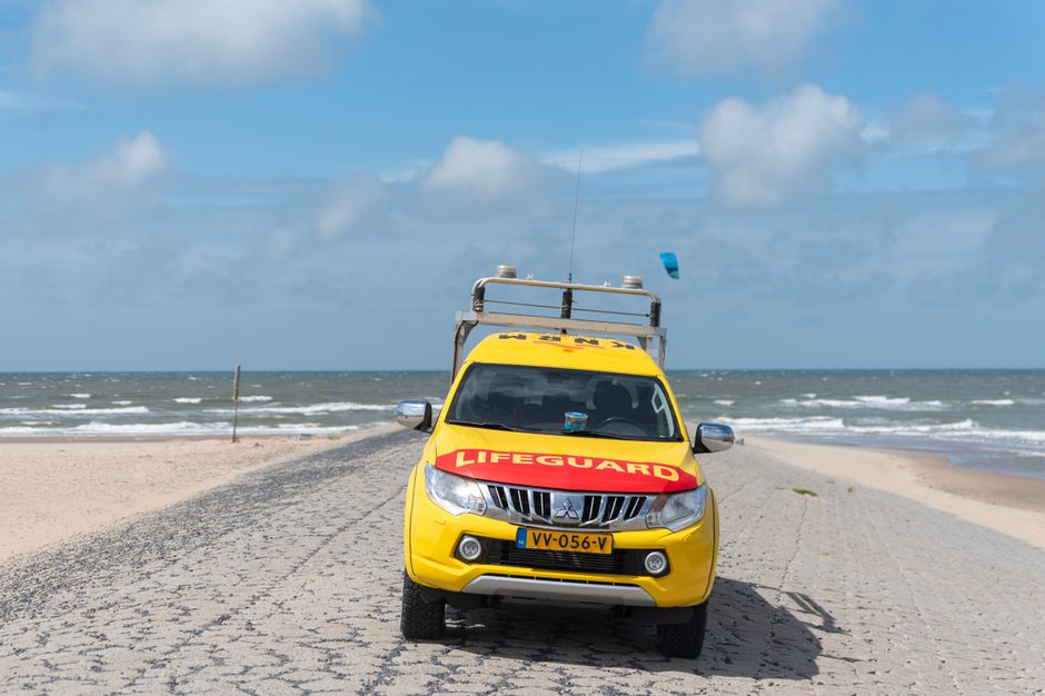 Yellow lifeguard vehicle stationed on Katwijk aan Zee beach in the Netherlands.