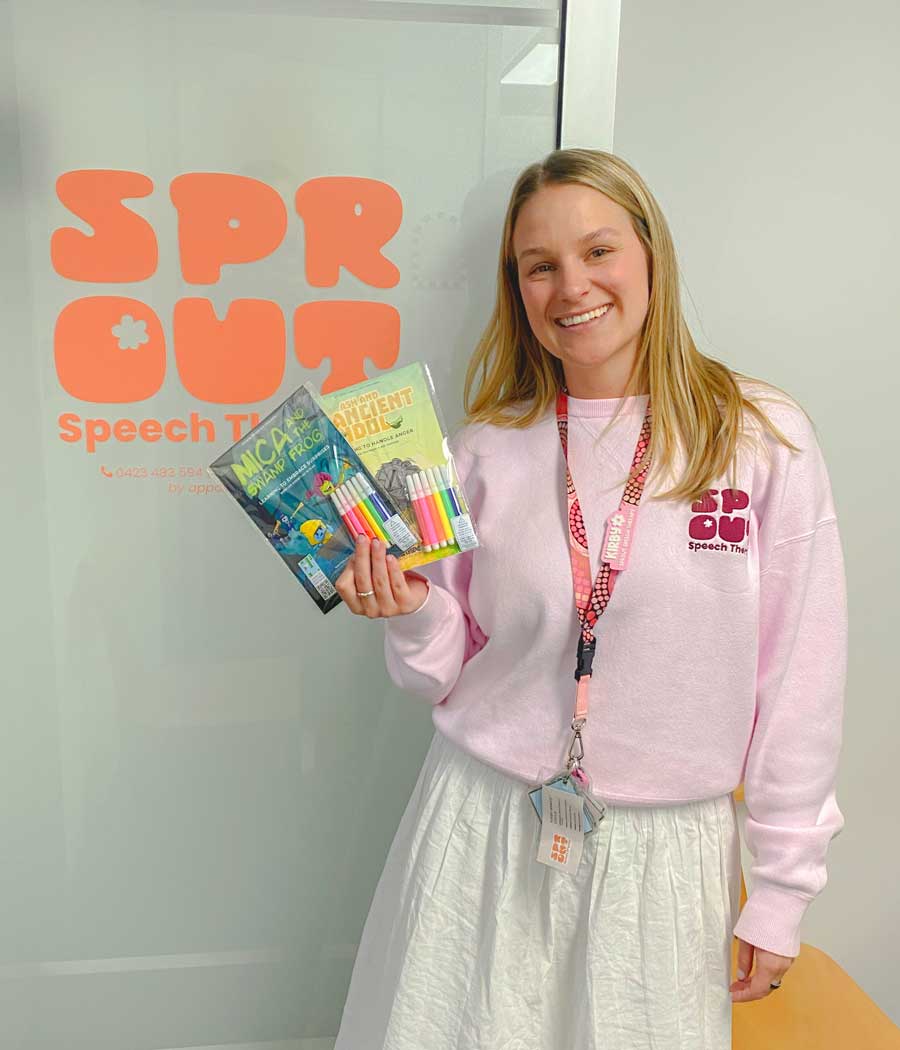 Kirby Doyle at Sprout Speech Therapy holding Little Legends comics