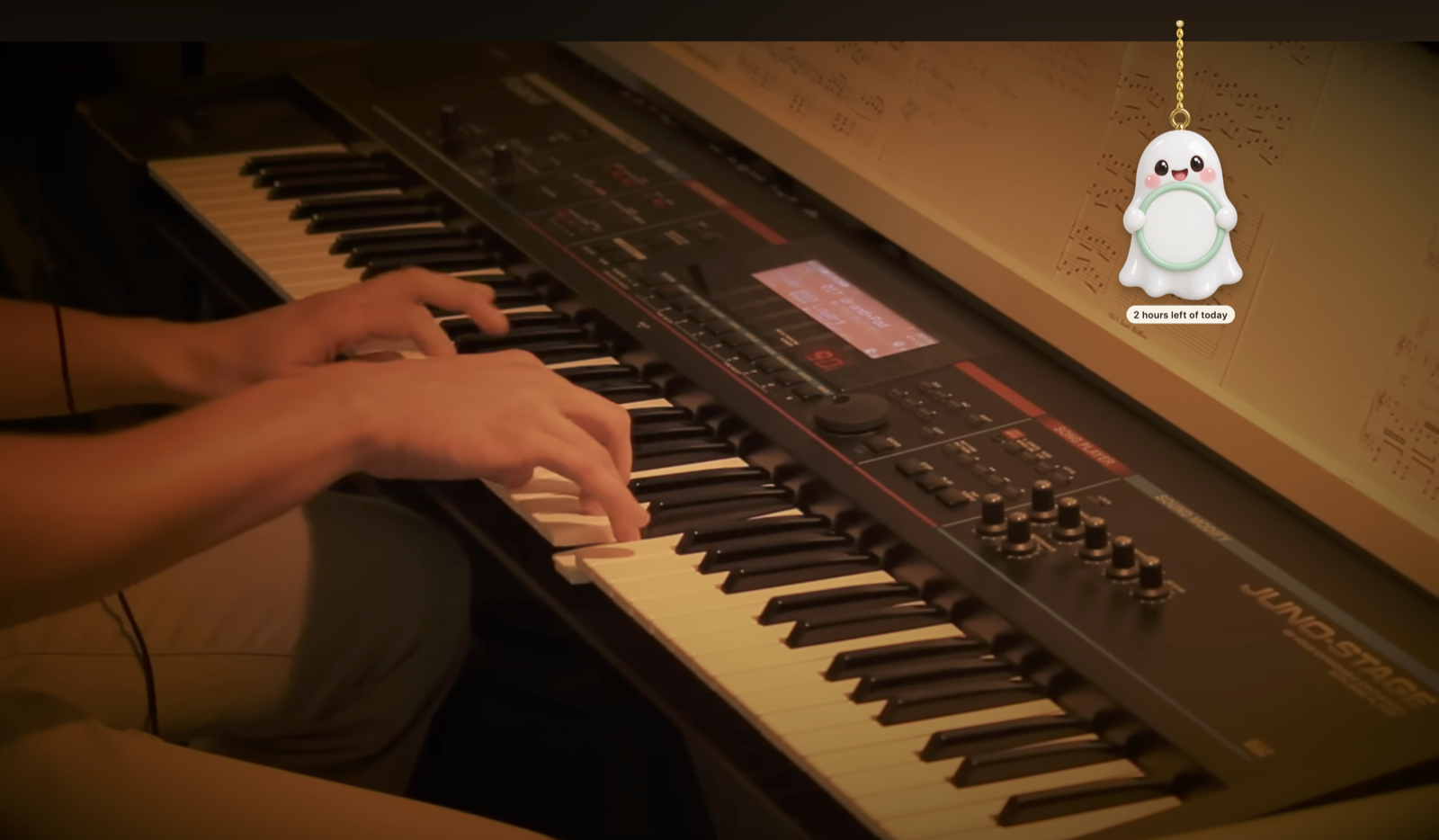 Boo the ghost charm hanging beside a piano video, holding a tag reading "2 hours left of today"