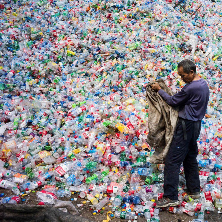 Man works in pile of plastic bottles