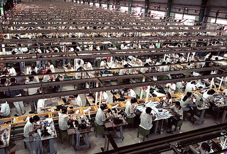 Factory workers sew clothes.