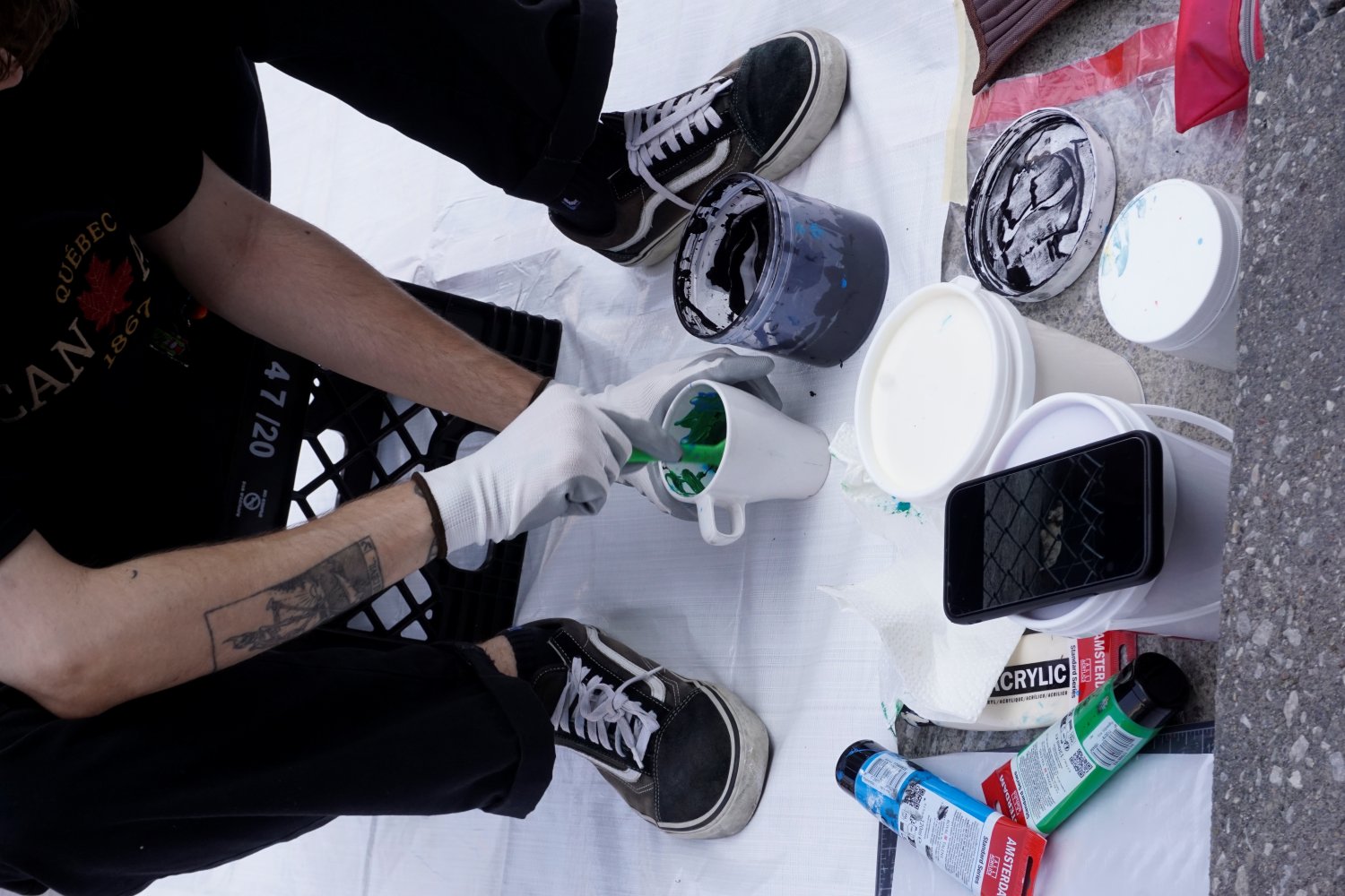 Louis painting on the street during the Yorkville Murals (YVM) Festival 2025