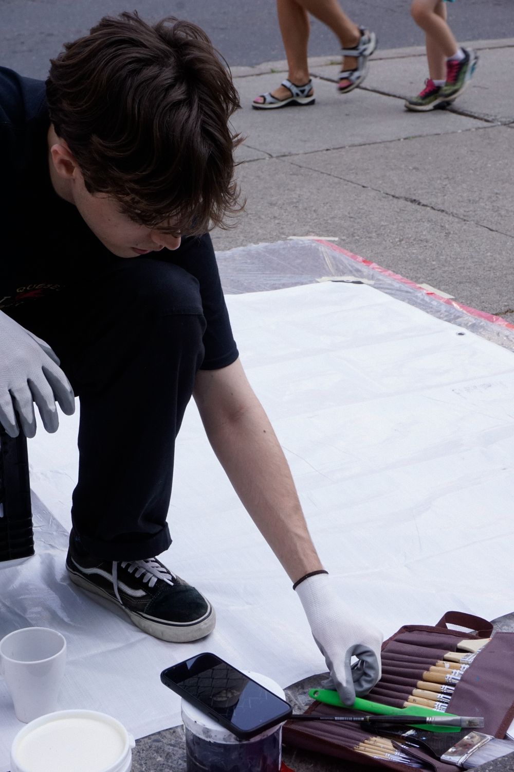 Louis painting on the street during the Yorkville Murals (YVM) Festival 2025