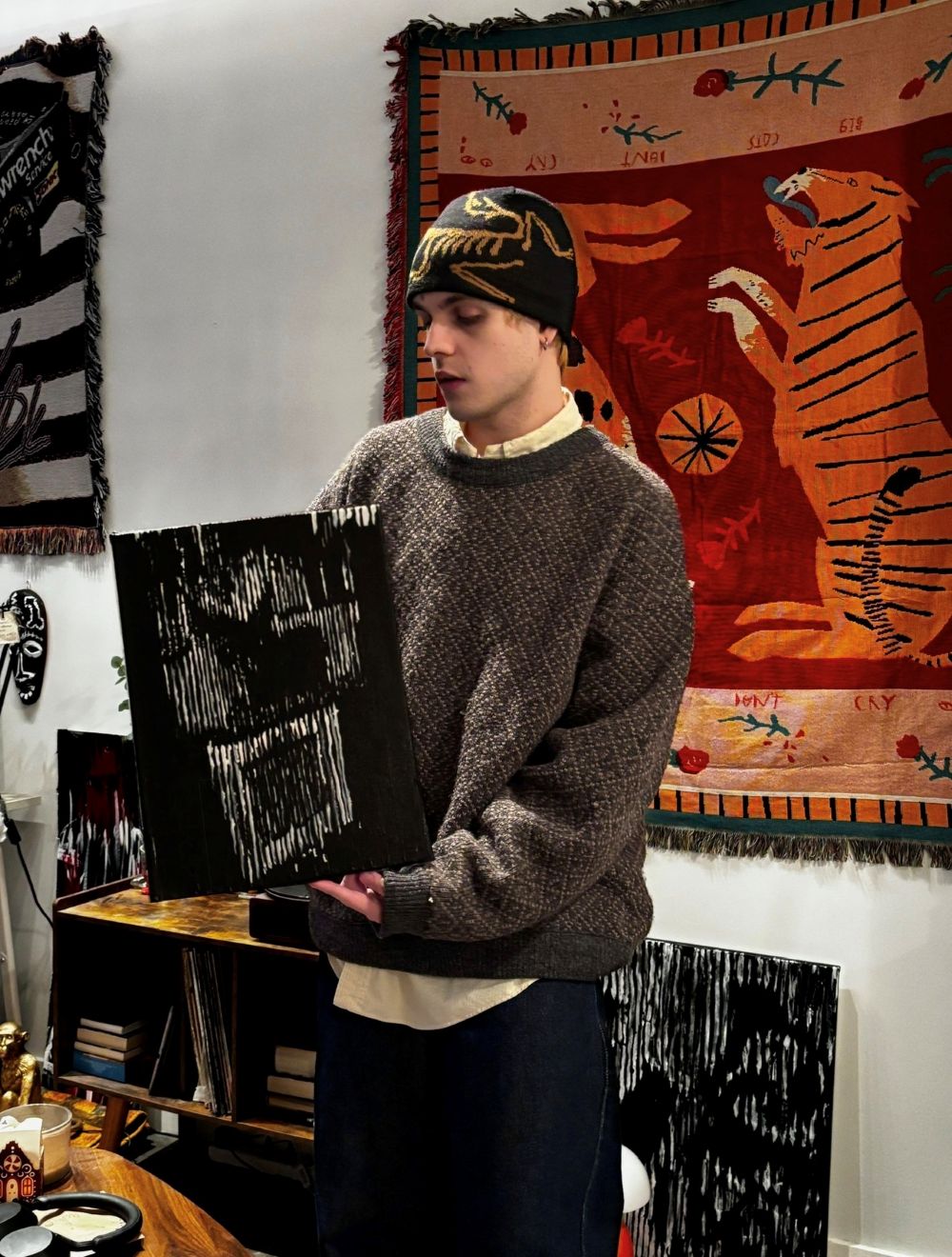 Louis holding 'Untitled, 2026' in his apartment's living room