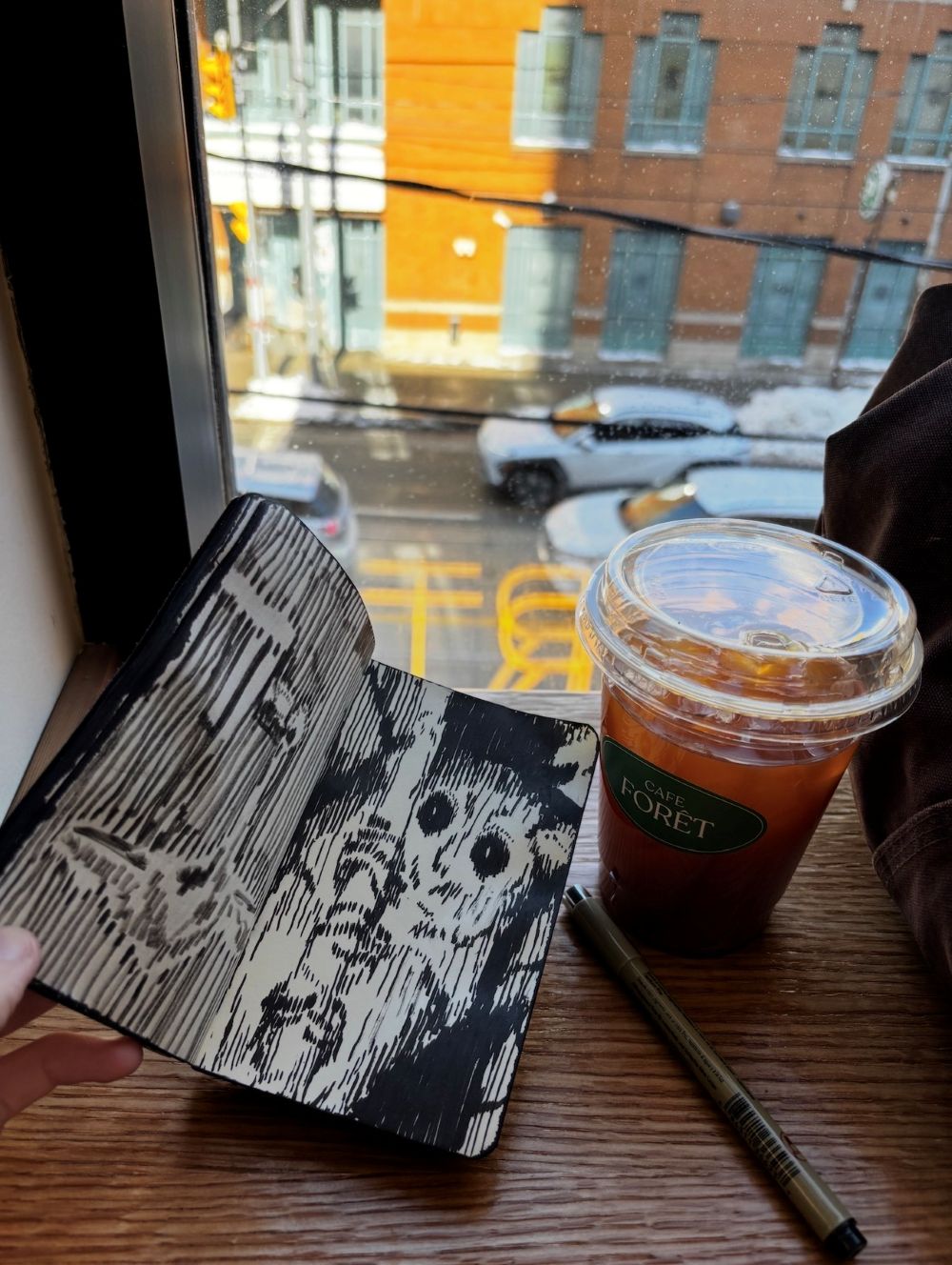Louis sketching in his 'Black Book' at Cafe Foret on Dundas Street, Toronto