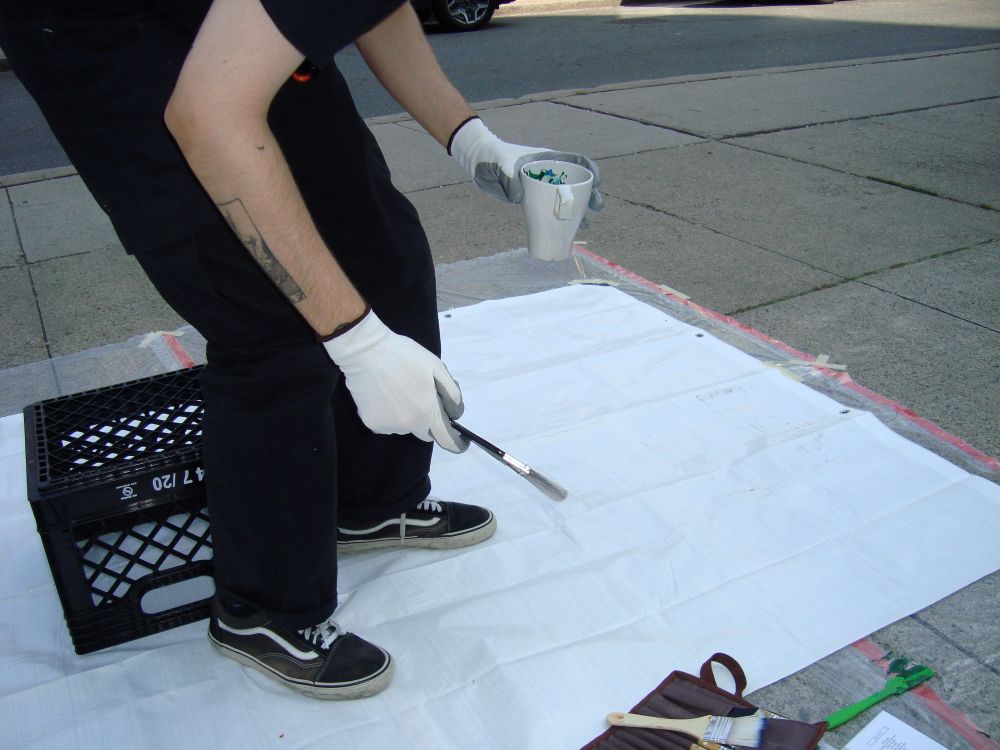 Louis painting on the street during the Yorkville Murals (YVM) Festival 2025