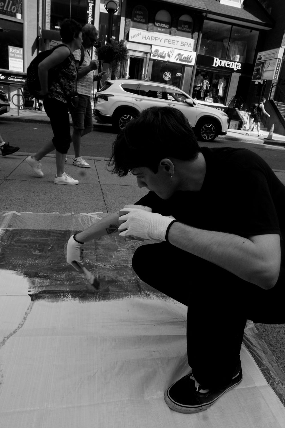 Louis painting on the street during the Yorkville Murals (YVM) Festival 2025