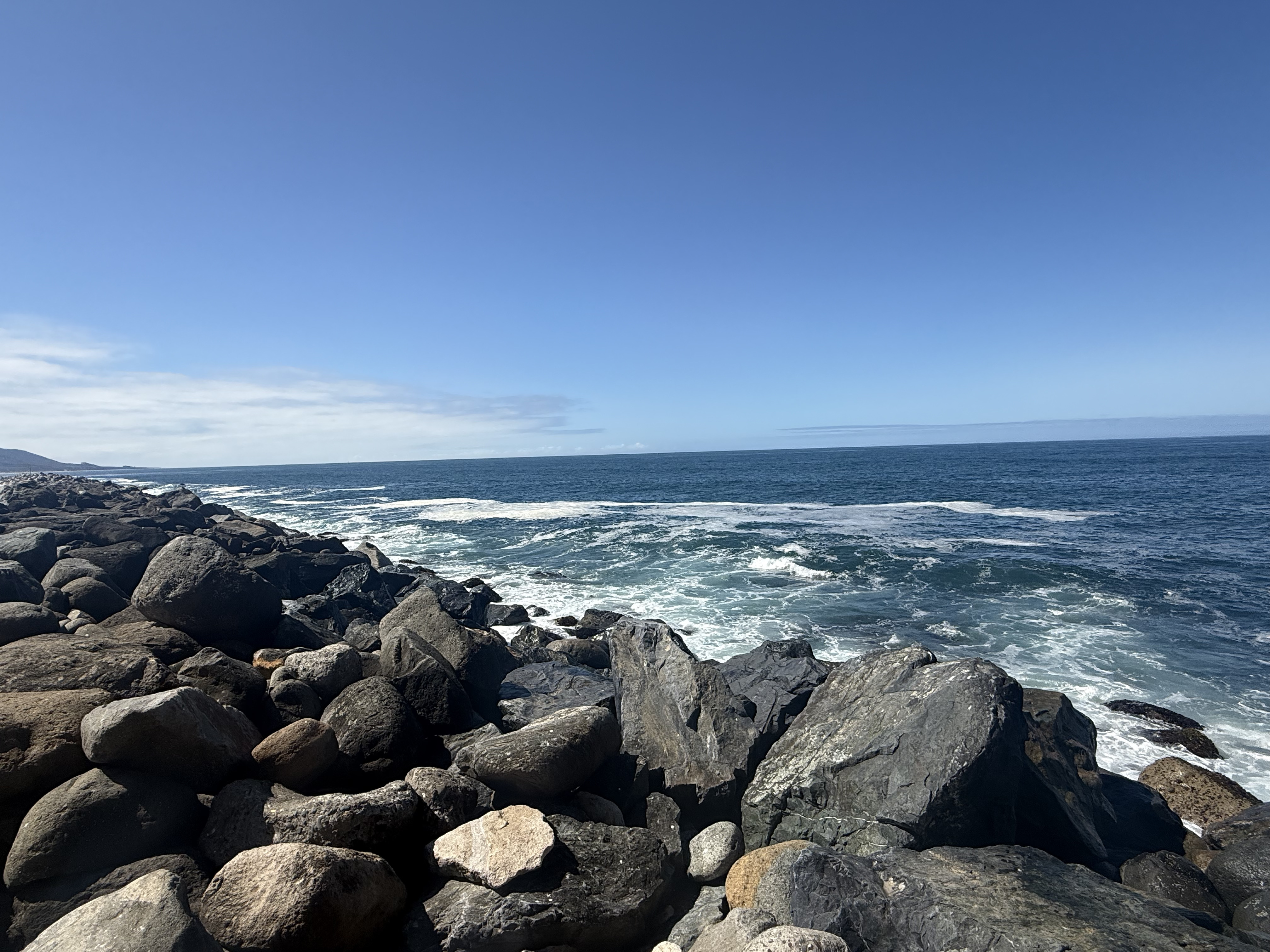 Rocky coastline beneath a clear blue sky