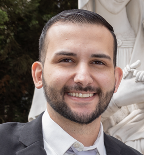 Foto de perfil de um desenvolvedor sorrindo, com fundo desfocado